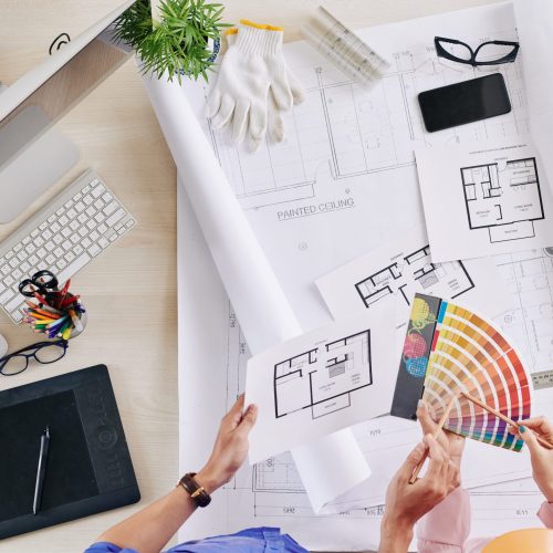 Color palette and apartment plans in hands of architect and engineer